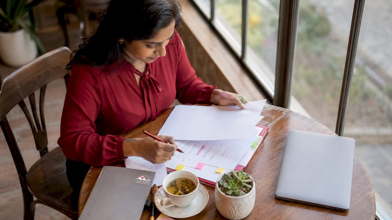 Woman reviewing FHSA documents at kitchen table